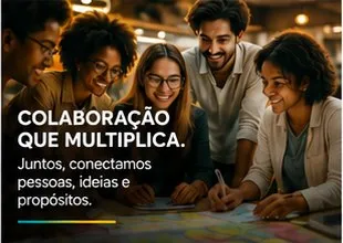 Jovens sorrindo reunidos em volta de uma mesa com papéis coloridos